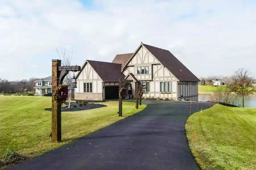 A cottage like home with a long driveway.